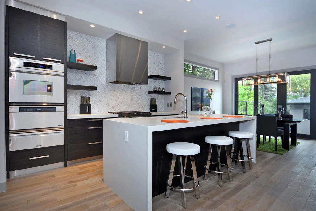 A modern kitchen features a sleek design with dark cabinetry and a large island